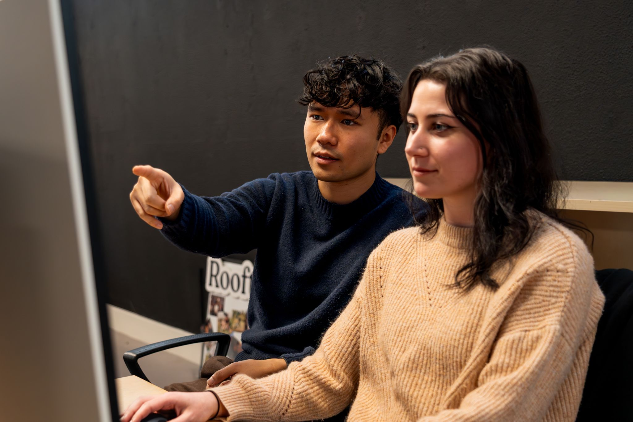 Two Rooftop team members reviewing work on screen